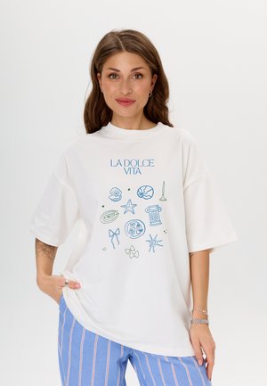 Witte oversized t-shirt met een blauw en groen geïllustreerd ontwerp met schelpen, sterren en een zuil. Zacht materiaal, relaxed fit.