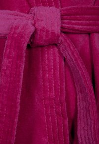 Fleece-Bademantel in lebhaftem Fuchsia mit einem strukturierten, gerippten Design. Verfügt über einen Bindegürtel und weichen, plüschigen Stoff für besonderen Komfort.