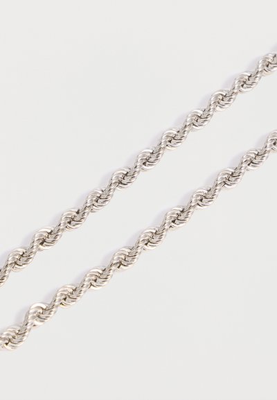 Δύο παράλληλες ασημί στριφογυριστές αλυσίδες σχοινιού σε απλό λευκό φόντο, που δείχνουν κοντινή λεπτομέρεια των συνδέσμων.
