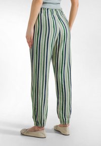 Randiga byxor med vertikala gröna, marinblå och cremefärgade ränder; elastisk midja; avslappnad passform med samlade muddar; lättviktigt tyg.
