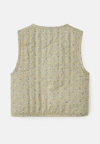 Ärmeles väst i ljusgrön tyg med blommönster, som har en texturerad yta med små blå och vita blomdesigner.