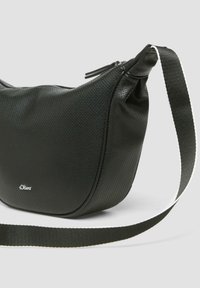 Schwarze synthetische Umhängetasche mit strukturierter Oberfläche, gebogener Form, Reißverschluss und einem kontrastierenden weißen Streifen am verstellbaren Tragegurt.