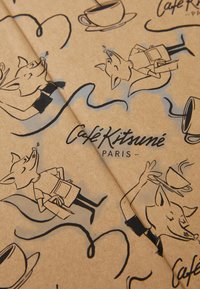 Kraft papiroverflate med svarte illustrasjoner av stiliserte rever og kaffekopper; har teksten "Café Kitsuné Paris."