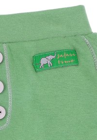 Zielona bawełniana bluzka z trzema guzikami, z metką przedstawiającą ilustrację słonia oraz złotym napisem "safari time".