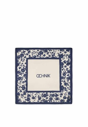 Kwadratowa biała apaszka z granatowym kwiatowym obramowaniem i granatowym ramieniem w środku, na którym widnieje nazwa marki w stylizowanych literach.