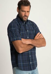 Camicia a maniche corte a scacchi blu navy in cotone, con colletto button-down, bottoni bianchi e taschino sul petto con motivi a contrasto.