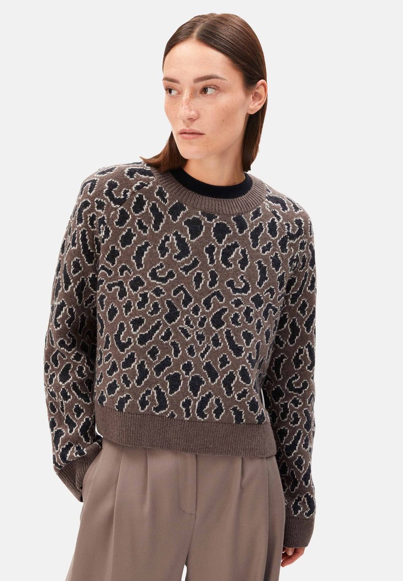 Maglione marrone lavorato a maglia con stampa leopardata in nero e beige. Presenta un collo rotondo e polsini e orlo a coste. Tessuto liscio, modello pullover.