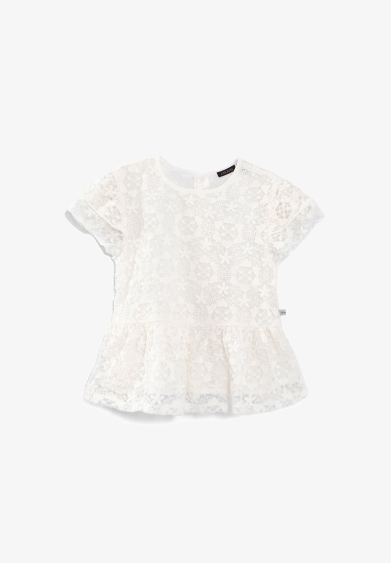 Blouse blanche à manches courtes en dentelle avec motif floral et bas à volant, col rond et tissu semi-transparent.