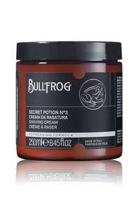 Braunes Glasgefäß mit schwarzem Deckel. Das Etikett zeigt weißen Text und eine Illustration eines Frosches. Enthält 250ml erfrischender Rasiercreme.