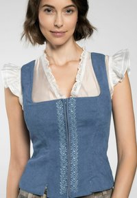 Blauwe corduroy gilet met een rits aan de voorkant, met bloemrijke borduursels in het midden. Mouwen gemaakt van doorschijnende, gerimpelde witte stof.