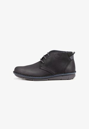 Botas de cuero negro hasta el tobillo con punta redonda, cordones de dos ojales, costuras azul oscuro y suela de goma. Textura suave, diseño minimalista.