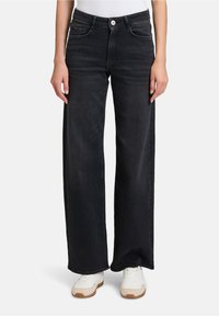 Czarne dżinsy o szerokich nogawkach, wyposażone w kieszenie z przodu, zamek błyskawiczny z zapięciem na guzik i białe akcenty w szwie.
