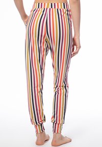 Gestreifte Jogginghosen aus einem weichen Stoff, mit vertikalen Streifen in Rot, Orange, Gelb, Lila und Creme sowie elastischen Bündchen und einem elastischen Bund.