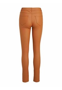 Pantalon slim fit couleur rouille avec deux poches arrière, passants pour ceinture et coutures visibles, vu de dos sur fond blanc.