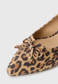 Leopard print ballet flats with a pointed toe, made of soft material, featuring a knot detail on the front. Color scheme includes tan and dark brown.