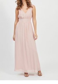 Robe maxi en rose clair, composée d'un tissu transparent, présente un décolleté en V, un design sans manches, une taille ajustée et une jupe fluide.