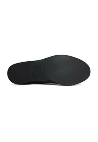 Black footwear sole with a textured surface, rounded shape, and subtle branding; made of rubber, providing stability and grip.