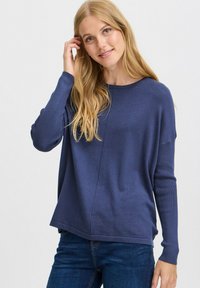 Pulover tricotat de culoare albastru marin, cu guler rotund, manșete cu textură ribbed și o textură moale, având un detaliu de cusătură elegant pe față.