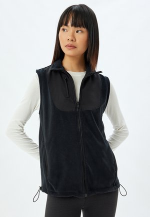 Zwart fleece vest met een ritssluiting aan de voorkant, beschikt over een glad zwart paneel op de borst, zijzakken en verstelbare trekkoorden aan de onderkant.