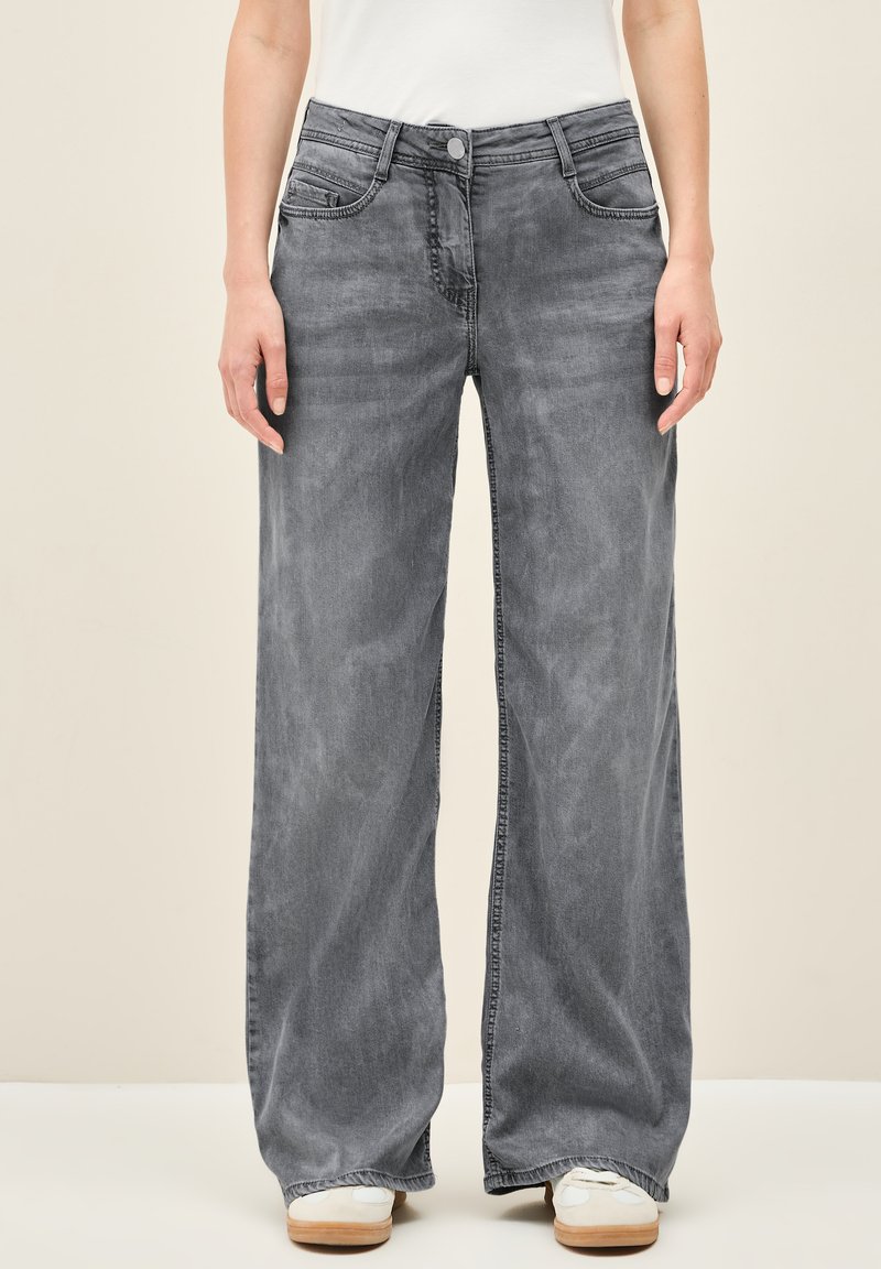 Wijde jeans in vervaagd grijs denim, met vijf zakken, knoop- en ritssluiting en contrasterende stiksels langs de naden.