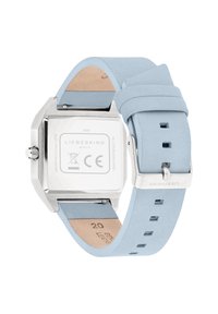 Quadratische Edelstahluhr mit einem weichen hellblauen Lederarmband, ausgestattet mit einer Edelstahl-Schließe und einem weißen Zifferblatt mit Markendetails.