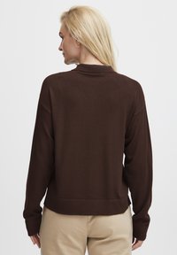 Brown sweater with a relaxed fit, long sleeves, and a round neckline. Soft knit texture, ribbed hem details, and minimal design.