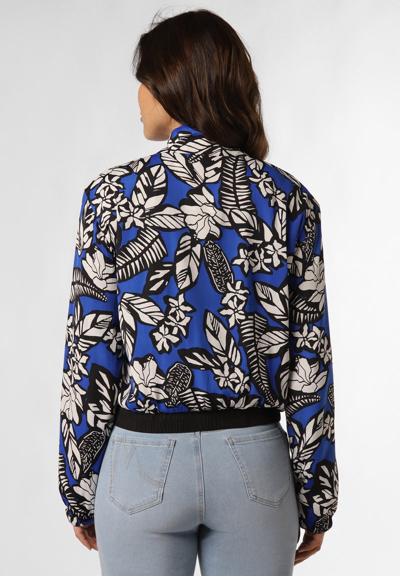 Blaue, kurz geschnittene Jacke mit einem botanischen schwarz-weißen Blumenmuster. Verfügt über einen elastischen Saum und elastische Bündchen, gefertigt aus leichtem Stoff.