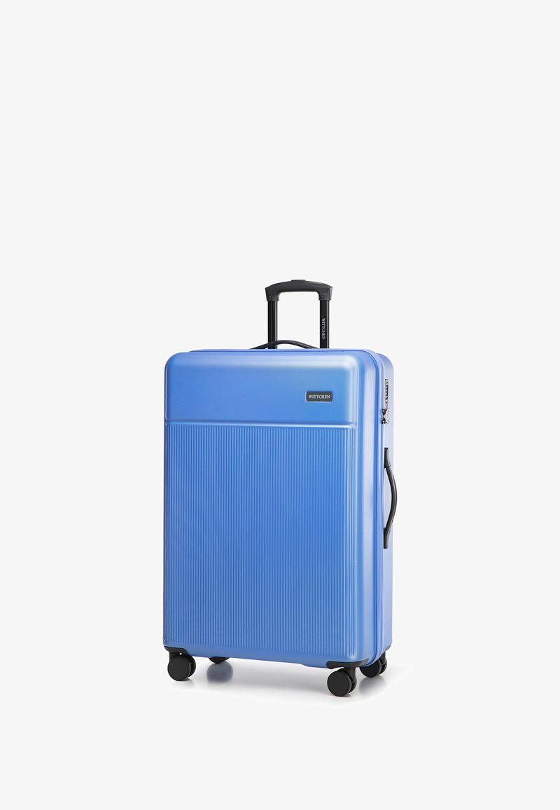 Blauwe harde koffer met verticale ribbelstructuur, uitschuifbare zwarte handgreep en vier wielen voor mobiliteit. Beschikt over een slot en handgreep.