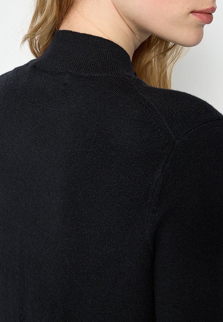 Czarny sweter dzianinowy z wysokim kołnierzem i subtelną fakturą, z raglanowymi rękawami i gładkim wykończeniem.