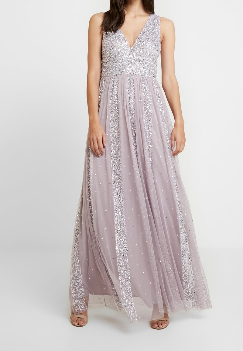 Maxikleid in Flieder mit V-Ausschnitt, verziert mit silbernen Pailletten und gepunkteten Details. Der fließende Stoff sorgt für einen eleganten Fall.