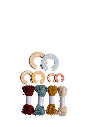 Wooden horse-shaped thread holders in various sizes and colors above four bundles of yarn in red, blue, yellow, and white on white background.