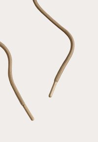 Beżowe sznurówki z plecionym wzorem, zakończone plastikowymi agletami. Materiał jest trwały i elastyczny w designie.