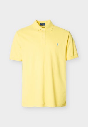 Polo de manga corta amarillo con cuello, dos botones y un pequeño logo bordado en azul en el pecho izquierdo.