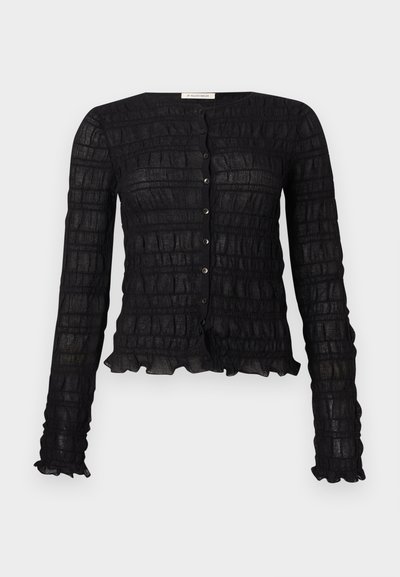 Μαύρο μακρυμάνικο πουκάμισο με κουμπιά, με υφασμένο μοτίβο πλέγματος και βολάν στα μανίκια και το τελείωμα.