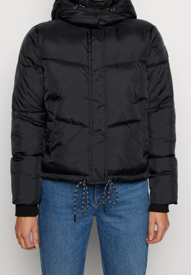 Chaqueta acolchada negra con capucha, diseño acolchado, dobladillo con cordón ajustable y puños elásticos. Fabricada en material de nailon brillante.