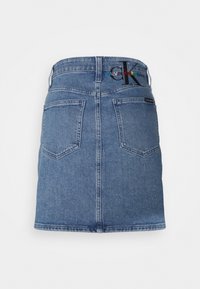 Džínová sukně světle modré barvy, s zadními kapsami a vyšívanou značkou. Rovný střih s lemem konč�ícím nad polovinu stehna.