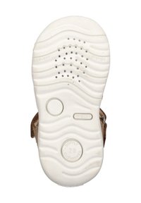 Bílá gumová podrážka s vlnkovým vzorem a malými otvory pro prodyšnost; hnědý vrchní materiál s přezkou pro bezpečné zapnutí.