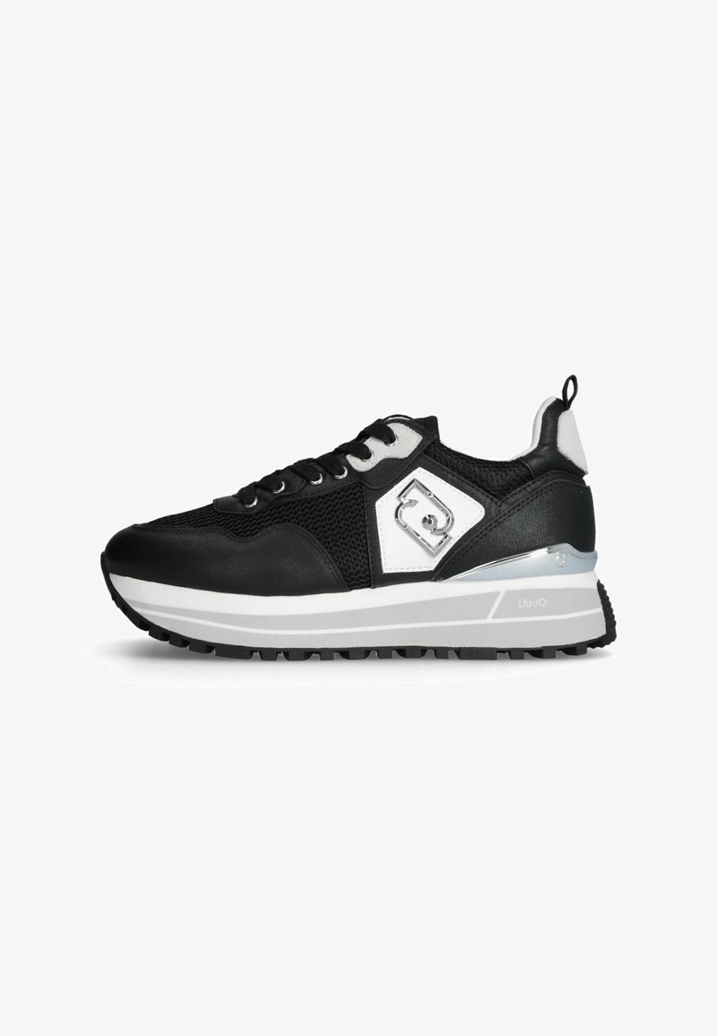 Schwarz-weißer Sportschuh mit dicker weißer Sohle, Mesh- und Lederobermaterial sowie einem metallischen Logodetail an der Seite.