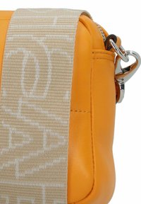 Borsa in pelle gialla con tracolla beige a fantasia, dotata di cerniera e accessori in argento. Design compatto con dettaglio di tasca laterale.