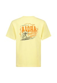 Keltainen puuvillapaita, jossa on graafinen kuvio "Aloha" ja "Chasing Waves" -tekstit, ja joita korostaa tyylitelty aalto-illustraatio. Lyhyet hihat.