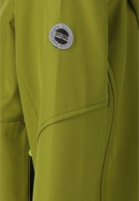 Oliven grøn softshell-jakke med et sølvfarvet cirkulært logo, glat tekstur og tydelig sømdetaljering på ærmerne.