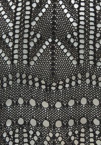 Schwarzer Spitzenstoff mit einem geometrischen Muster aus Zickzacklinien und kreisförmigen Öffnungen, das eine feine, strukturierte Oberfläche zeigt.