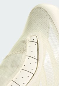 Cremefarbener Sneaker aus strukturiertem Material mit glatten Lederakzenten. Verfügt über Perforationen und dünne metallische Ösen für die Schnürsenkel.