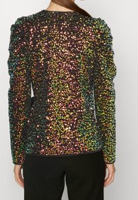 Blazer nero coperto di paillettes multicolori, con spalle imbottite e maniche lunghe. Texture liscia con un design aderente.