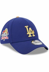 Blaues Baseballcap mit einem erhabenen goldenen "LA"-Logo und einem Patch "World Series Champions". Mit einem gebogenen Schirm und einem enganliegenden Design.