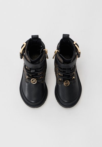 Black leather ankle boots with gold hardware, decorative side zippers, and a textured brown pattern on the sides. Rugged sole design.