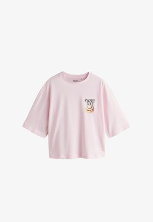 Roosa lühikeste varrukatega puuvillane T-särk. Vasakul rinnal on tekst "SWEET LIKE" ja keerise kujundus. Lõdva istumisega.