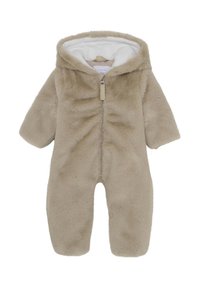 Beige nepbont overall met een witte binnenvoering, volledige ritssluiting en capuchon. Kenmerkend zijn de zachte textuur en de ronde mouwen voor extra comfort.