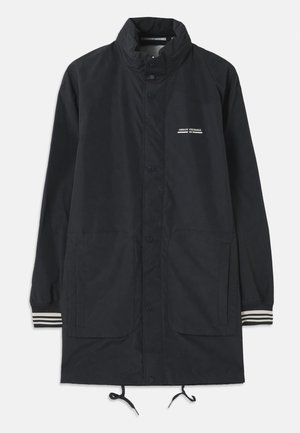 Marine vanntett jakke med høyt krage, trykknapper, to frontlommer og stripete mansjetter. Justerbar snor i kanten. Tekstlogo på brystet.