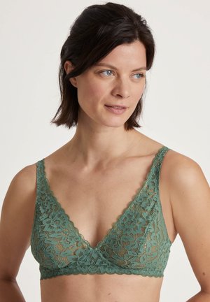 Lace bralette in gedempt groen met een driehoekige vorm, scalloped randen en een bloemenpatroon. Zachte textuur en verstelbare schouderbanden.